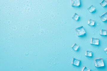Overhead photo of pile of cubes ice and drops isolated on the blue background with empty space