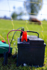 Electric fence with an electrical transformer and battery power pack in a field