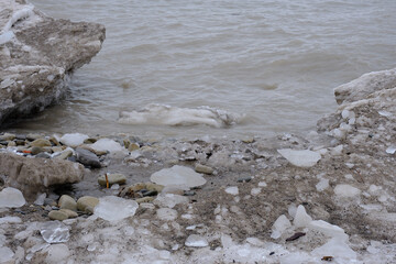 Ice floe buildup along the rocky shoreline of Lake Michigan on the United States side on a cloudy cold winter day