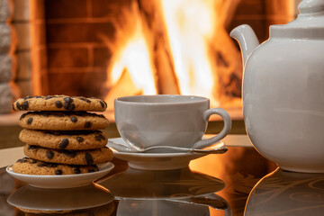 Cozy Fireplace,teapot and tea cup , cookies on a table.