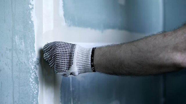 Worker Glues Plasterboard Joint With Paper Tape