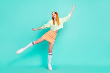 Fototapeta na wymiar Full length photo of cool millennial lady look empty space wear sport clothes skirt sneakers isolated on teal color background