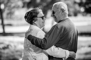 Senior adults walking in a park holding hands	