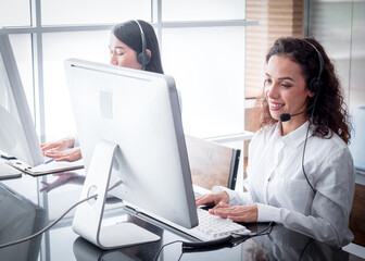 Concentrated female customer service wear wireless headset working in customer care support service...