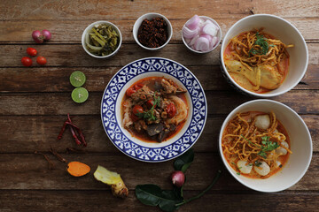 Local northern Thai food Egg noodle curry with chicken and meatball and Rice noodles on wood background