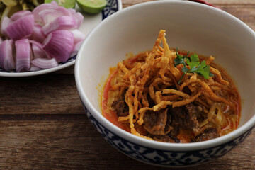 Local northern Thai food Egg noodle curry with beef on wood background