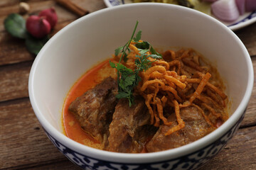Local northern Thai food Egg noodle curry with pork ribs on wood background