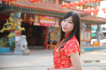 Obraz premium beauty woman wear red cheongsam looking and smile in chinese new year