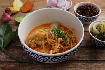 Local northern Thai food Egg noodle curry with chicken on wood background