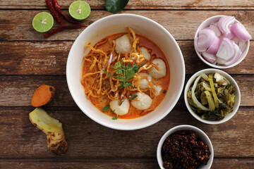 Local northern Thai food Egg noodle curry with meatballs on wood background