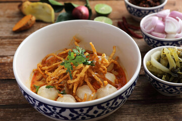 Local northern Thai food Egg noodle curry with meatballs on wood background