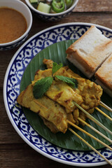 Local Thai food pork satay with oeanut dipping sauce isolated in wood background