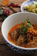 Local northern Thai food Egg noodle curry with pork ribs on wood background