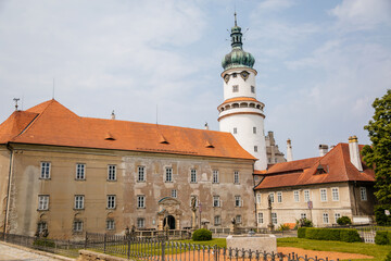 Fototapeta na wymiar Baroque romantic castle Nove mesto nad Metuji, renaissance chateau with round white clock tower, red tile roof, arched portal entrance, summer sunny day Eastern Bohemia, Czech Republic