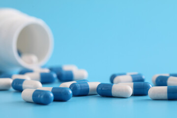 pills capsules with bottle isolated on blue background