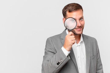 handsome businessman finfing with a magnifying glass