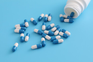pills capsules with bottle isolated on blue background