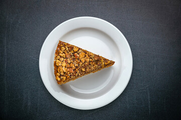 Honey cake on a white plate and a dark table
