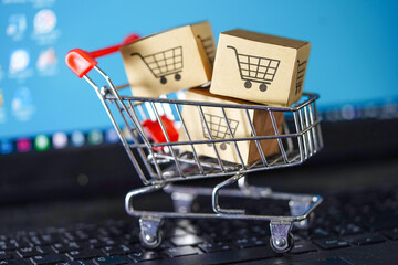 Shopping cart on notebook keyboard, online business import export concept.