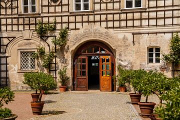 Baroque romantic castle Nove mesto nad Metuji, renaissance chateau, courtyard, Wooden lattice overgrown with greenery, sunny day, arched portal, entrance door, Bohemia, Czech Republic