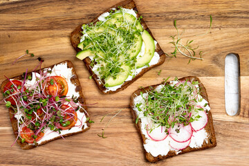 Varied breakfast, snacks sandwiches with wholegrain bread, toasters with cream cheese, radish,...