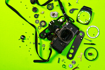 A vintage 35mm SLR film camera lies broken in pieces and presents the opportunity for a DIY repair...