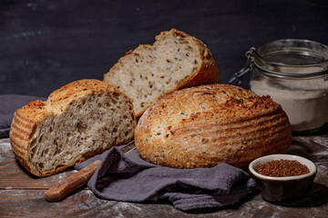 Traditional wheat freshly rustic baked bread with sliced on towel. Artisan sourdough bread with knife. 