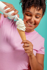 Black girl eating an ice cream cone on a turquoise background