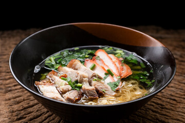 Chinese noodle in soup topped with roasted pork and crispy pork