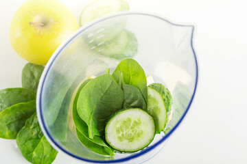Smoothie recipe. Ingredients for green smoothie: spinach, apple, cucumber in blender. Home cooking. Vegan healthy detox eating, dietary and weght loss drink.