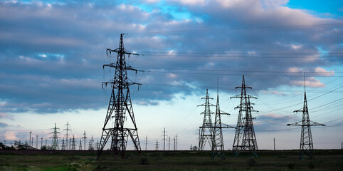 The clouds over the power lines are magnificent.Power lines and sky with clouds.Powerful lines of electric gears.Electric power industry and nature concept.High voltage power lines.Panorama.