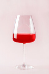 Still life with red refreshing summer alcoholic cocktail drink with strawberry in wine glass on pink background. Fruit or berry wine. Minimalism