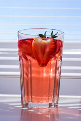 Still life with glass of cooling strawberry Sangria with sparkling wine, strawberry, ice cubes. Refreshing summer alcoholic cocktail drink , lemonade or ice tea. Copy space for text.