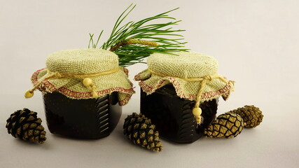 Unusual jam from pine cones in glass jar.   Vegetarian  dessert among pine branches and cones.  Organic cold medicine.
