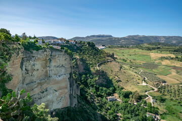 a landscape view of the green valleys and cliffsides surrounding Ronda in Southern Spain  - obrazy, fototapety, plakaty