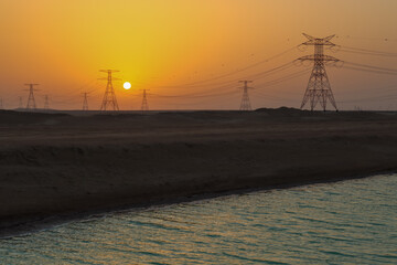 sunset among high voltage electric tower At Salt lake Abu Dhabi