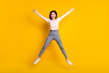 Full size photo of young smiling funky funny cheerful woman jumping in star pose isolated on yellow color background