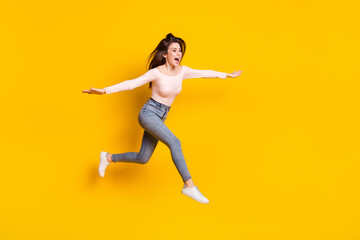 Fototapeta na wymiar Full size photo of young crazy excited funky woman jumping flying look copyspace isolated on yellow color background