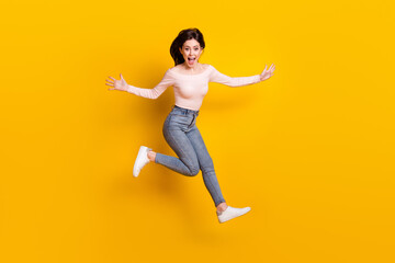 Fototapeta na wymiar Full size photo of young happy excited funky girl jumping running in iar screaming isolated on yellow color background