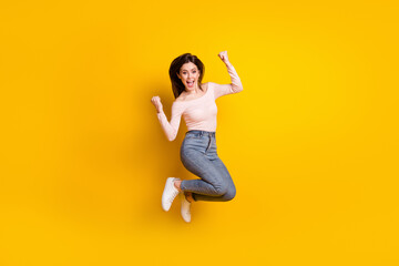 Fototapeta na wymiar Full size photo of young happy excited cheerful woman jumping in victory success isolated on yellow color background