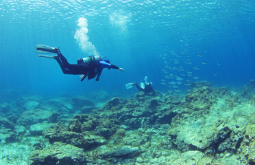 Diving instructor and student in underwater exercise. Instructor teaches student to dive. Underwater scuba diving education and training.