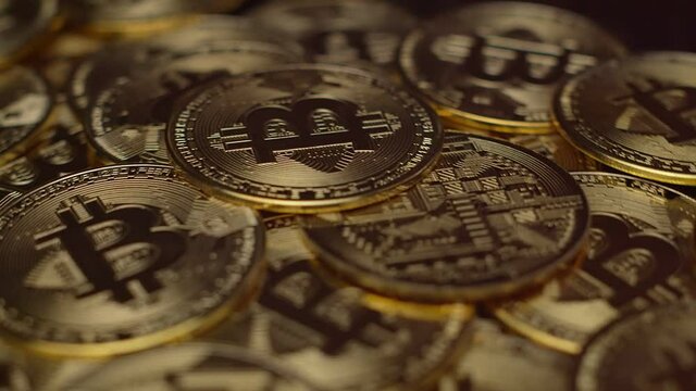 Deal a lot bitcoin coins are spinning on the table. Top view gold coins with the image of bitcoin, close-up. Concept of electronic currency