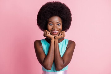 Photo of young happy positive smiling pretty afro girl hold hands chin admiring isolated on pink color background