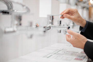 young man choosing a bathroom/kitchen tap in a home furnishings retail store