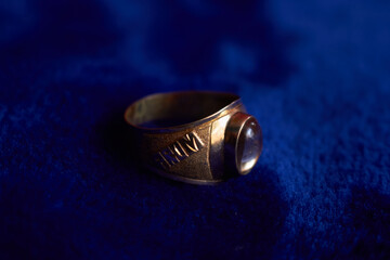 A gold colored ring on the bed