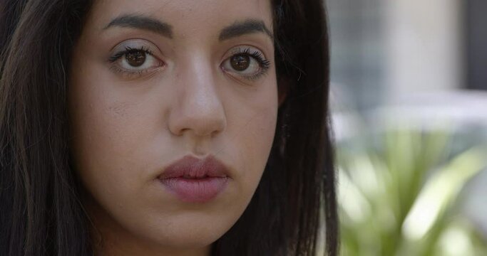 beautiful face of young moroccan woman staring at the camera blinking - macro