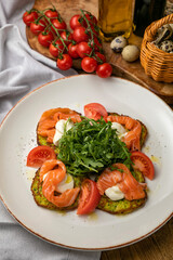 Salmon, cheese, tomatoes on croutons on a wooden table
