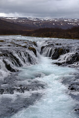 Bruarfoss waterfall in Iceland showing it's true blue colors on a cold spring day