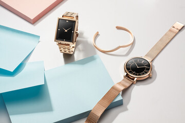 Woman watches and accessories on table with blank paper note