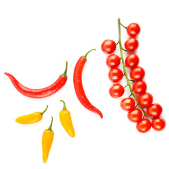 Cherry tomatoes and chili peppers isolated on white .